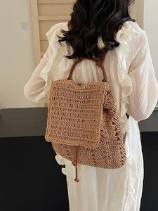 Stylish woven straw backpack with brown leather straps for summer vacation