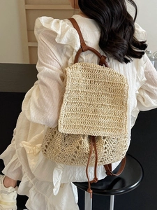 Women's woven straw backpack in beige with brown leather straps for summer vacations