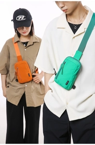 Detail of vibrant nylon crossbody bags featuring vertical zippers and woven logo tags