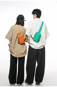 Detail of adjustable nylon crossbody bags in vibrant orange and green colors