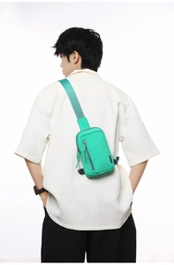 Close-up of green nylon crossbody bag showing the durable texture and vertical zipper detail