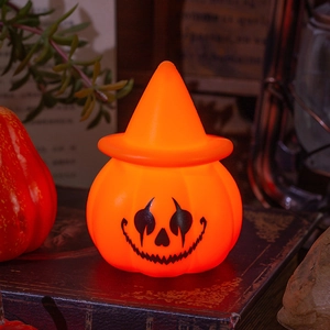 Glowing Halloween pumpkin wizard night light on vintage books for party table decoration