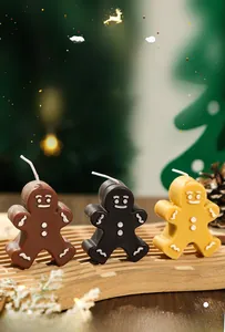 Detailed view of gingerbread man scented candles in brown, black, and yellow festive sets