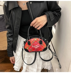 Mini-Umhängetasche mit Karomuster und Apfelprint, Handtaschenstil an einem Model