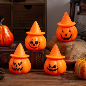 Close-up of four orange LED pumpkin lights with wizard hats for Halloween table decor
