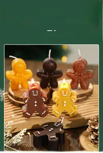 Close-up of gingerbread man scented candles with icing details on festive wooden base