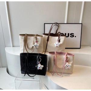 Detailed close-up of large tote bags with embossed patterns and star plush charms