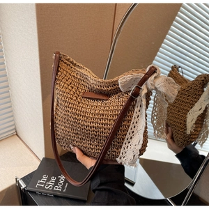 Close-up of woven straw bucket bag featuring a white lace bow and leather strap