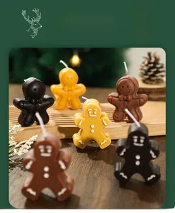 Close-up of gingerbread man scented candles in brown and yellow with festive decor
