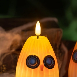 Vue rapprochée de la bougie LED chouette citrouille avec flamme et surface texturée