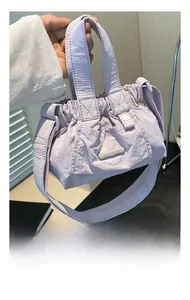 Close-up of lilac nylon bucket bag with drawstring detail and mini rubber logo brand