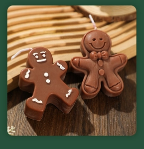 Detailed macro view of two gingerbread man scented candles with white cotton wicks