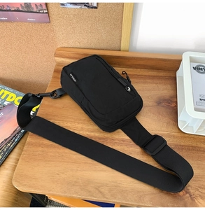 Detail of durable black nylon crossbody bag with adjustable strap and brand label