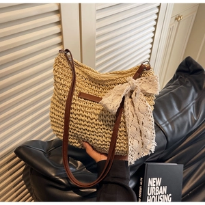 Detailed macro view of woven straw bucket bag with white lace bow and leather strap