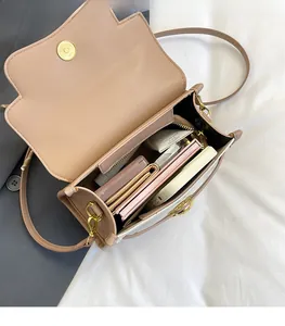 Detail view of the spacious internal compartments and magnetic closure of this beige crossbody bag