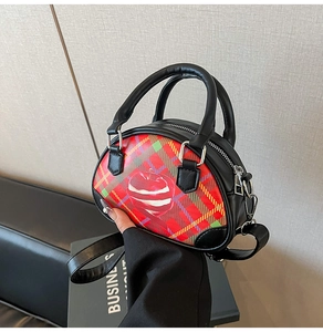 Detail der Retro-Karo-Handtasche mit Apfelprint und eleganten schwarzen Schultergurten