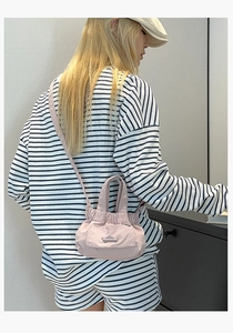 Detail of pink pleated mini bucket bag with ruffled top and small front flap pocket