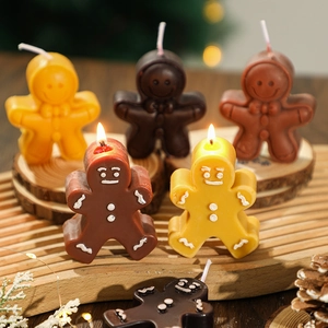 Gingerbread man scented candles in various colors on a festive wooden Christmas tray