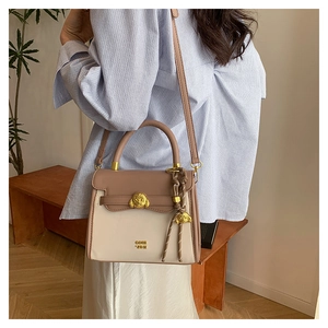 Detail of retro small square bag with golden animal clasp and woven rope ornament