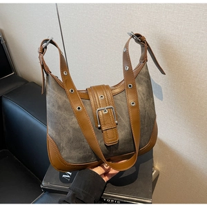 Détail d'un sac vintage gris avec rivets argentés et garniture en cuir brun sur des livres