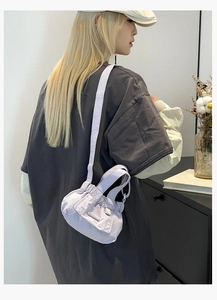 Detailed view of lilac pleated nylon bucket bag with adjustable wide shoulder strap