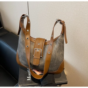 Détail du sac rétro montrant les finitions en cuir marron et la boucle en métal argenté