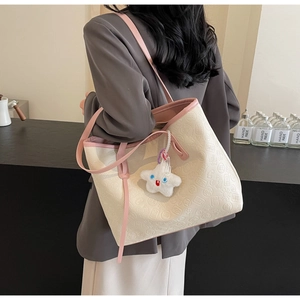 Detail of embossed traditional Chinese patterns on beige tote bag with star charm