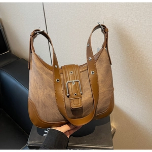 Détail du sac hobo vintage montrant le patchwork de toile et cuir brun et la bandoulière