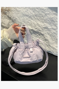 Detail of light purple pleated nylon mini bucket bag with brand logo and handles
