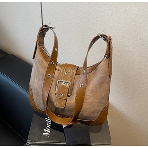 Détail d'un sac bandoulière vintage en toile avec ceinture en cuir et œillets
