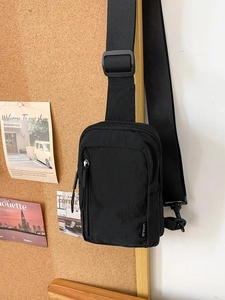 Minimalist black nylon crossbody bag with adjustable wide strap and multi-pocket design