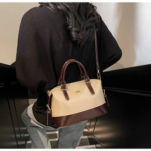 Detail of Boston bag with contrast color stitching and shiny patent leather accents
