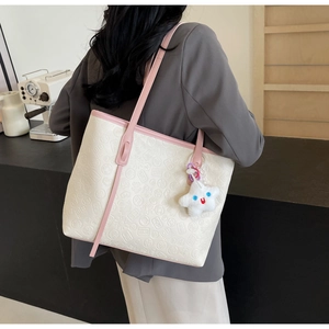 Detail of embossed tote bag with Mahjong texture and pink handle for women