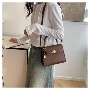 Detail of vintage brown leather crossbody bag featuring gold dog clasp and COIN 2DN logo