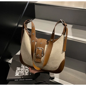 Détail de la bandoulière réglable et boucle en métal sur le sac hobo en toile beige