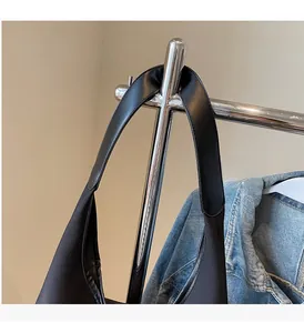 Close-up of black canvas tote bag handle with reinforced leather stitching and sturdy texture