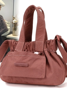 Pink pleated nylon cloud crossbody bucket bag with adjustable shoulder strap and logo