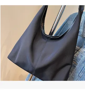 Close-up of a black canvas tote bag made from soft nylon fabric with reinforced straps