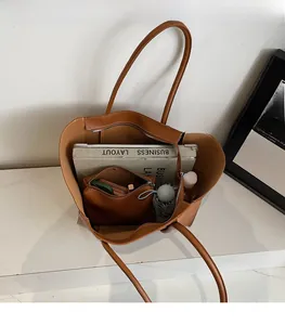 Interior view of large brown tote bag showing spacious capacity and matching pouch