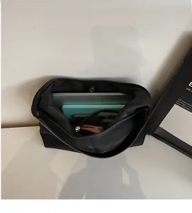 Spacious interior of black canvas tote bag holding a laptop, tablet and wallet