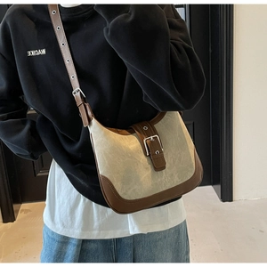 Détail d'un sac bandoulière vintage en toile beige avec finitions en cuir marron