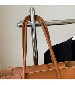 Detail of caramel brown tote bag with thick comfortable straps and white contrast stitching