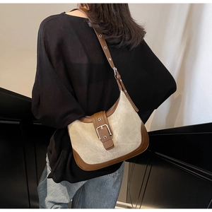 Détail du sac hobo rétro bicolore avec bandoulière en cuir marron et boucle argentée