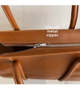 Detail showing high-quality silver zipper and smooth hardware on brown tote bag