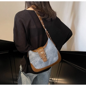Détail du sac hobo en tissu denim avec finitions en cuir marron et boucle métallique