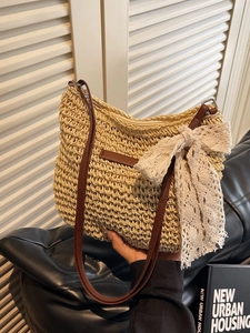 Straw woven shoulder bag with white lace bow and brown leather strap for beach