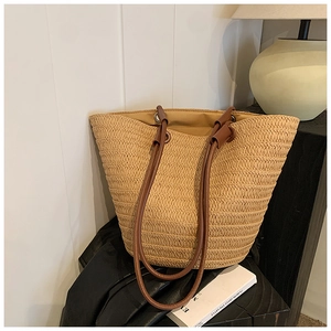 Minimalist straw woven tote bag with dark brown leather straps for spring and summer