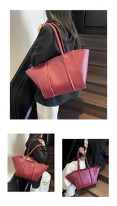 Detail of burgundy tote bag showing embossed fashion text and contrast stitching
