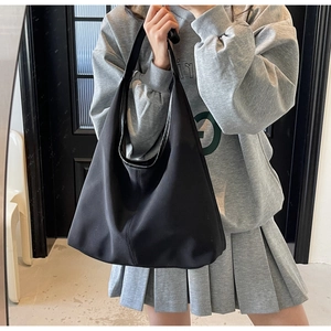 Model wearing a black large capacity nylon hobo shoulder bag for daily commuting style