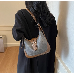 Détail du sac hobo vintage en toile, finitions en cuir marron et bandoulière ajustable
